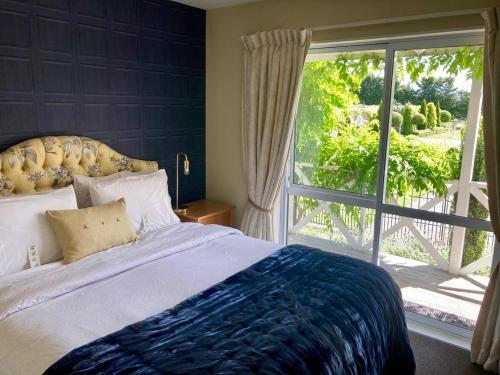 a bedroom with a bed and a large window at Willowtree Cottage Gated Country Luxury Near Lincoln Uni & Wedding Venues in Lincoln