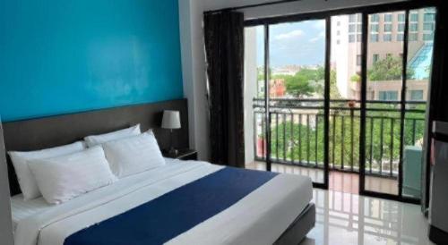 a bedroom with a large bed and a large window at Chada Veranda Hotel in Ban Si Than
