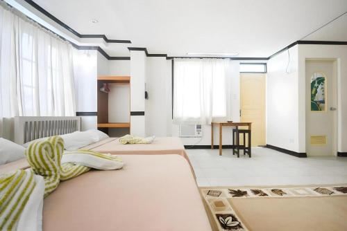 a large room with two beds and a table at Boracay Breeze Resort in Boracay