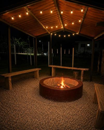 a fire pit in a patio with two benches at Doña Eneida Cabin in Soná