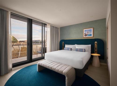 a bedroom with a large bed and a large window at Adina Sydney Darling Harbour in Sydney
