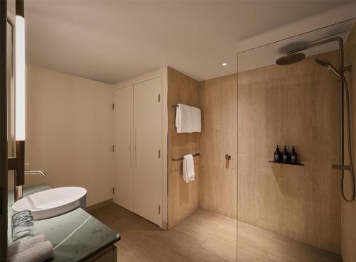 a bathroom with a toilet and a glass shower at Adina Sydney Darling Harbour in Sydney