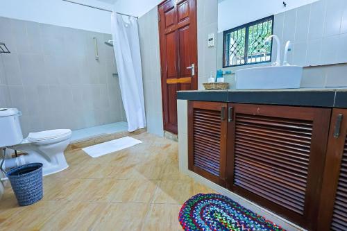 a bathroom with a sink and a toilet and a shower at Janari Stays in Kilifi