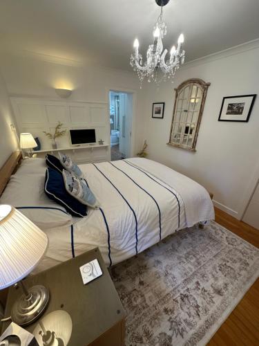 a bedroom with a bed with a table and a chandelier at Tre Mynach Barmouth in Barmouth