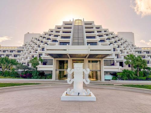a large white building with a statue in front of it at Paradisus by Meliá Cancún -All Inclusive in Cancún