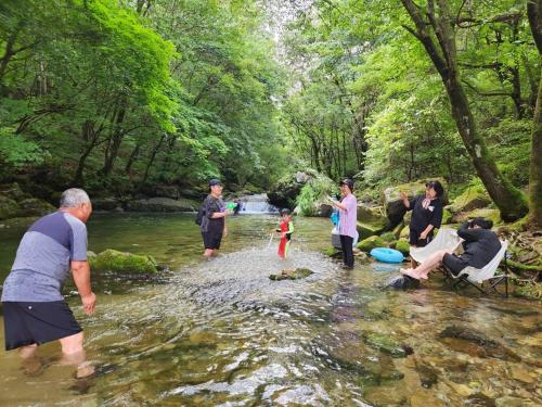 a group of people standing in the water in a river at Hwacheon Sankkun-uijib Pension in Hwach'ŏn
