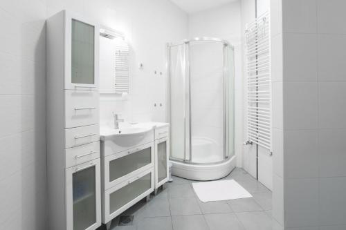 baño blanco con ducha y lavamanos en Apartments Zagreb Point - Vinogradska, en Zagreb