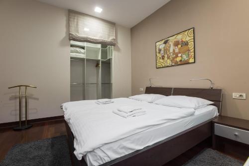 a bedroom with a bed with white sheets and a window at Apartments Zagreb Point - Vinogradska in Zagreb