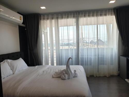 a bedroom with a bed with two stuffed animals on it at The High One in Ban Laem Thaen