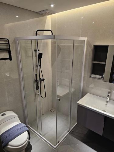 a bathroom with a shower and a toilet and a sink at Annapurna Resort Puncak in Tagalbato