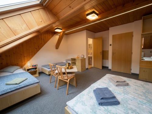 a attic room with two beds and a kitchen at Krásná pod Lysou horou in Krásná