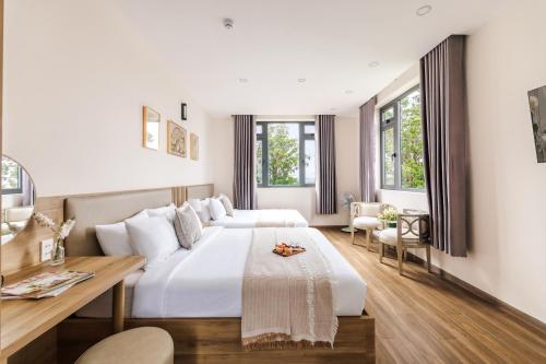 a hotel room with two beds and a desk at DO Hotel in Da Lat