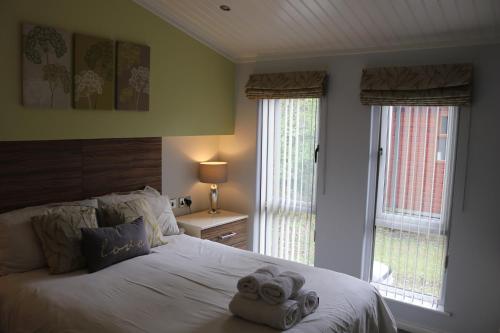 a bedroom with a bed with two towels on it at High View Lodge in Windermere