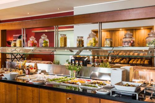 a buffet line with many plates of food at Hotel Wolfsburg Centrum, Affiliated by Meliá in Wolfsburg