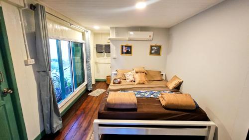 a room with two beds in a room with a window at ชบาเฮาส์โฮมสเตย์ 