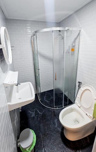 a bathroom with a shower and a toilet and a sink at ชบาเฮาส์โฮมสเตย์ 