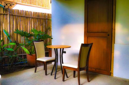 a table and chairs in a room with a plant at RECA Resort Philippines Luxury Villas & Nature Retreat in Porac