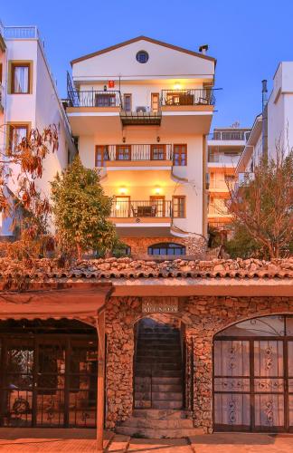 a large white building with a staircase in front of it at Hotel Kayahan in Kas