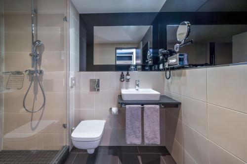 a bathroom with a toilet and a sink and a shower at INNSiDE by Meliá Berlin Mitte in Berlin