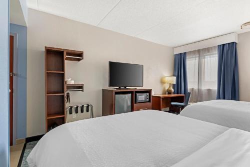 a hotel room with two beds and a flat screen tv at Garner Hotel Warren Northwest by IHG in Warren