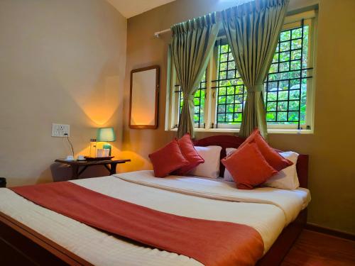 a bedroom with a large bed with a window at Pear Mount Farm House in Kodaikānāl