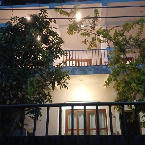 a white house with a balcony with a railing at villa calm haven in Unawatuna