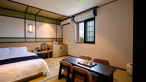 a hotel room with a bed and a table and a desk at Mitasuya Ryokan Hotel Daejeon Yuseong in Daejeon