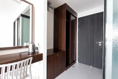 a bathroom with a mirror and a wooden door at Rockstar Beach Apartments in Bangrak Beach