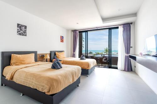 two beds with teddy bears on them in a bedroom at Rockstar Beach Apartments in Bangrak Beach