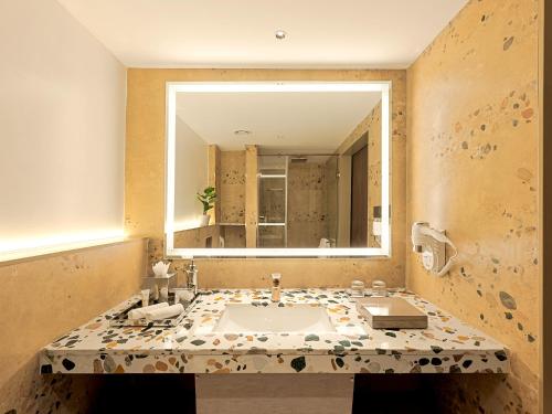a bathroom with a sink and a large mirror at Gateway Goa, Palolem in Palolem
