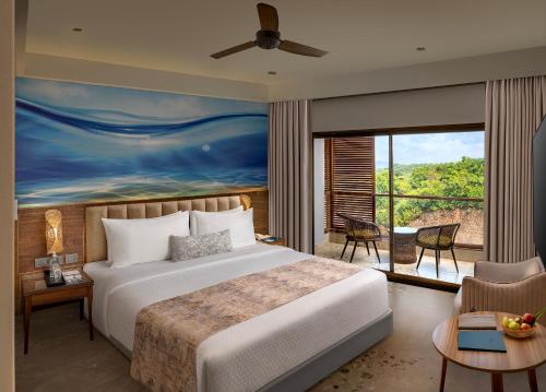 a bedroom with a bed and a large window at Gateway Goa, Palolem in Palolem