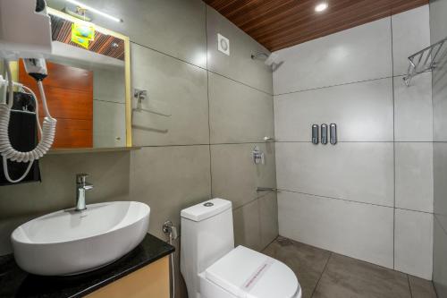 a bathroom with a white toilet and a sink at Wood Panda Luxury Resort Wayanad in Meppādi