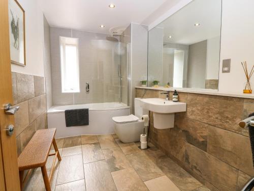 a bathroom with a toilet and a sink and a tub at Whitehouse Woodwrae in Forfar