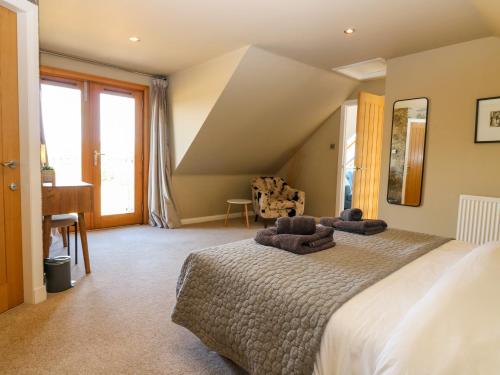 a bedroom with a large bed with towels on it at Whitehouse Woodwrae in Forfar