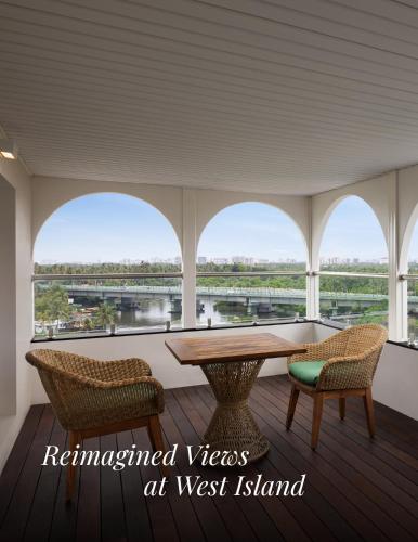 a room with a table and chairs and windows at Le Meridien Kochi in Cochin