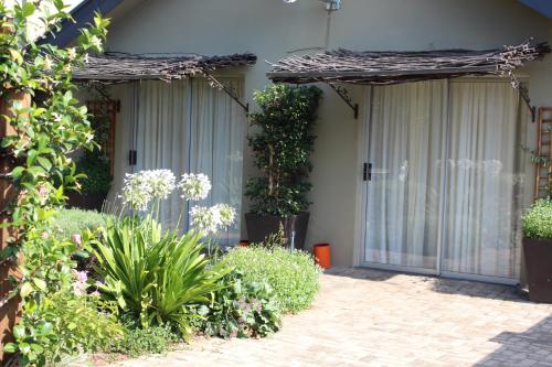 a house with two glass doors and some plants at Danlee Overnight Accommodation in Polokwane