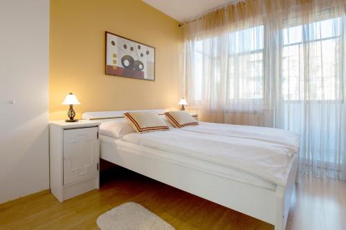 um quarto com uma grande cama branca e uma janela em Apartment Cvetje em Zagreb