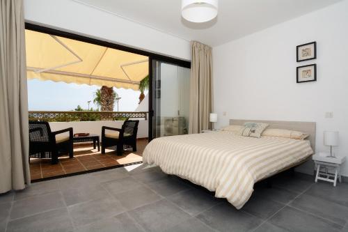 1 dormitorio con 1 cama, mesa y sillas en Playa Grande Puerto del Carmen Share Pool By PVL, en Puerto del Carmen