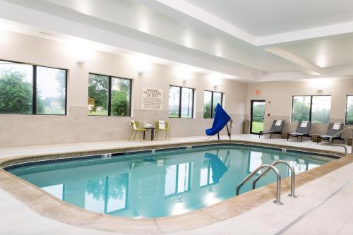a pool in a hotel with chairs and a table at Hampton Inn & Suites Addison in Addison