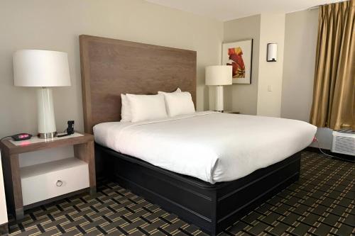 a large bed in a hotel room with two lamps at Sleep Inn & Suites Peoria North in Peoria