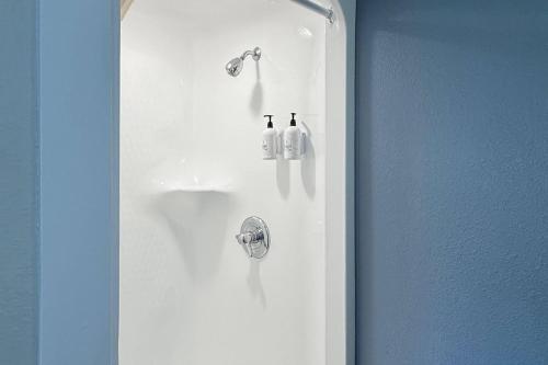 a bathroom with a shower with two bottles on the wall at Sleep Inn & Suites Peoria North in Peoria