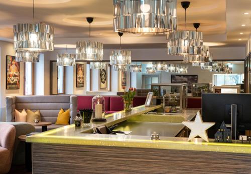 a bar in a restaurant with chandeliers at elaya hotel hannover city, Trademark by Wyndham in Hannover