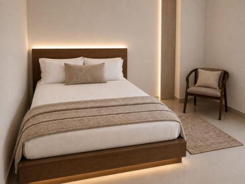 a bedroom with a large bed and a chair at Oval View Residencies in Yakbedda