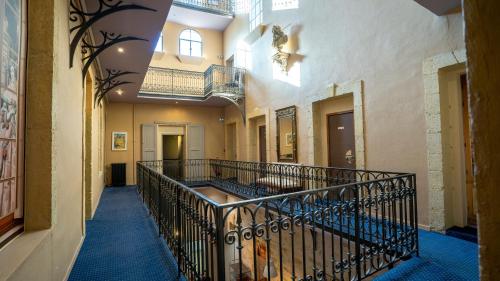 an empty hallway with a staircase in a building at The Originals Boutique, Le Grand Hôtel Molière, Pézenas in Pézenas