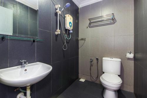 a bathroom with a white toilet and a sink at Hotel O Crystal City Hotel in Kuantan