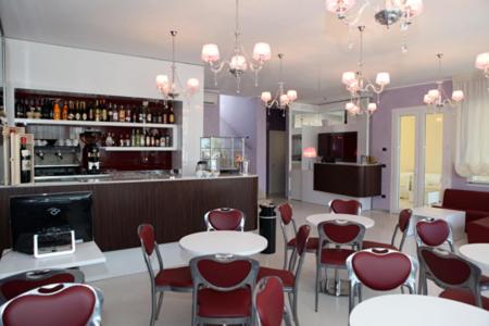 een restaurant met tafels en stoelen en een bar bij Hotel Perla Dello Ionio in Torre Lapillo