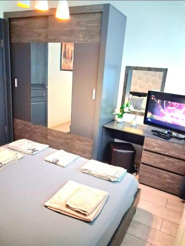 a room with a bed with a desk and a monitor at Juls 2 bed flat- Bulgaria mall FREE parking in Sofia