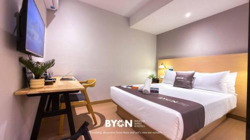 a hotel room with a bed and a desk at The Tapir Puchong by BYON Premium Suites & Hotels in Puchong