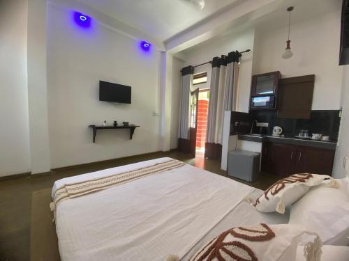 a bedroom with a large bed and a tv at Sea Tide by Jade Rock in Negombo