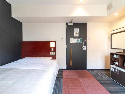 a bedroom with a bed and a tv at SUPER HOTEL Tokyo Akabane Station Higashiguchi Ichibangai in Tokyo